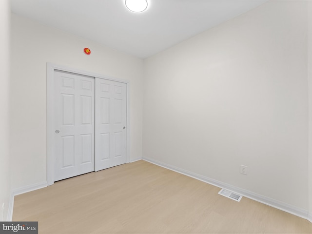 unfurnished bedroom with light hardwood / wood-style floors and a closet