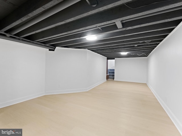 basement with light hardwood / wood-style flooring