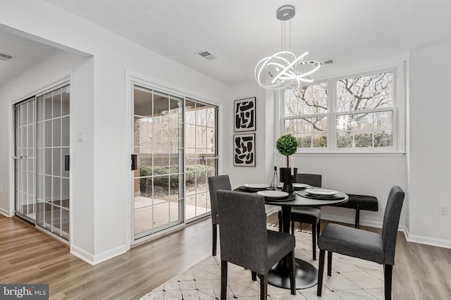 dining area featuring a notable chandelier and light hardwood / wood-style flooring