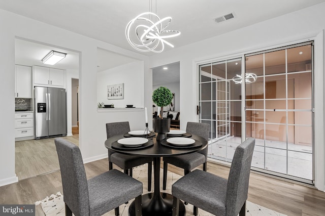 dining area featuring an inviting chandelier and light hardwood / wood-style flooring