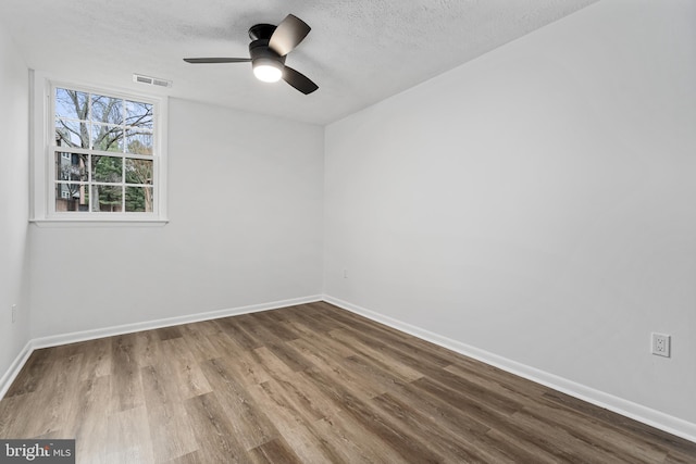 spare room featuring ceiling fan, wood-type flooring, and a textured ceiling