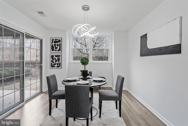 dining space featuring plenty of natural light, a chandelier, and light hardwood / wood-style flooring