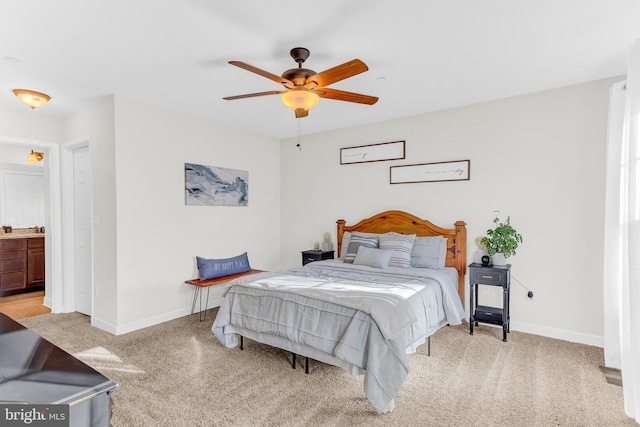 bedroom featuring ensuite bath, ceiling fan, and light colored carpet