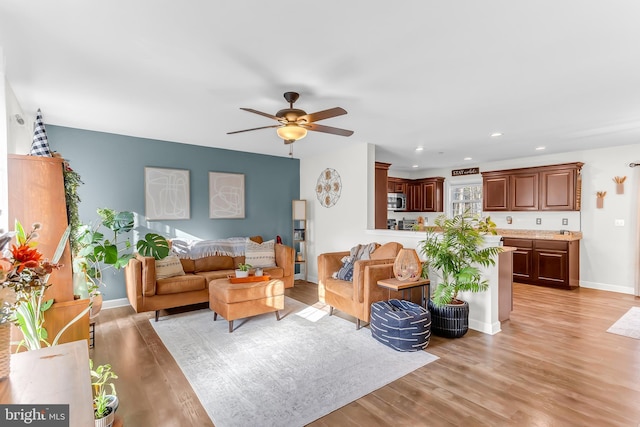 living room with ceiling fan and light hardwood / wood-style floors