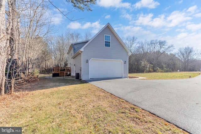 view of side of property featuring a garage, a yard, a deck, and central air condition unit