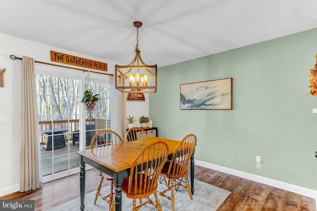 dining room with hardwood / wood-style floors and a notable chandelier