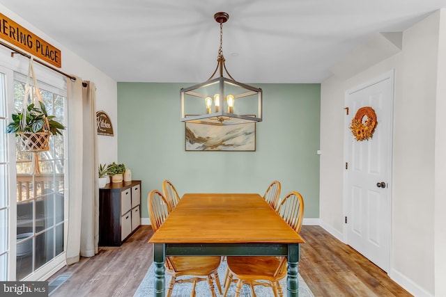 dining area featuring hardwood / wood-style floors and an inviting chandelier