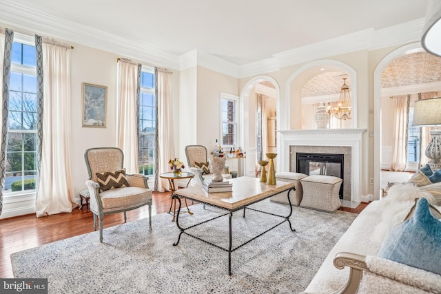 living area featuring a healthy amount of sunlight, light hardwood / wood-style flooring, and crown molding