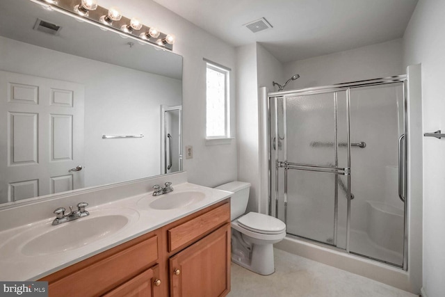 bathroom featuring vanity, a shower with shower door, and toilet