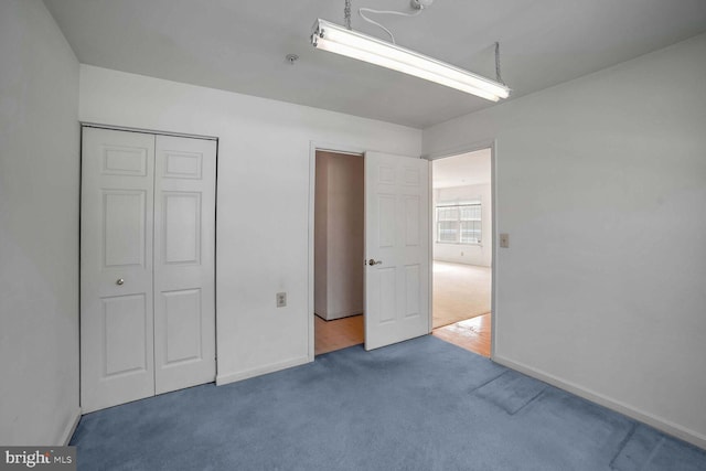 unfurnished bedroom featuring carpet flooring and a closet