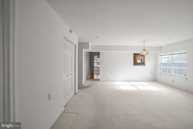 spare room featuring light colored carpet