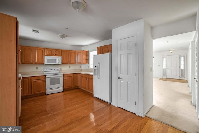 kitchen featuring white appliances and light hardwood / wood-style floors