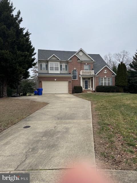 view of front of home featuring a garage, a balcony, and a front yard