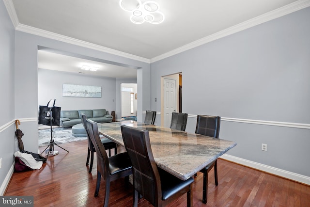 dining room with crown molding and wood-type flooring