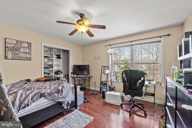 bedroom with wood-type flooring, ceiling fan, and a closet