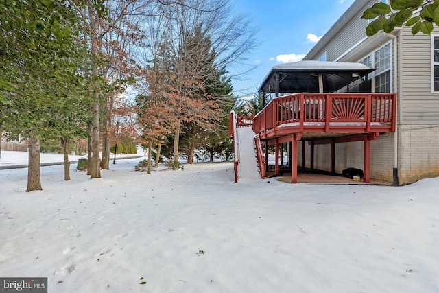 yard layered in snow with a deck