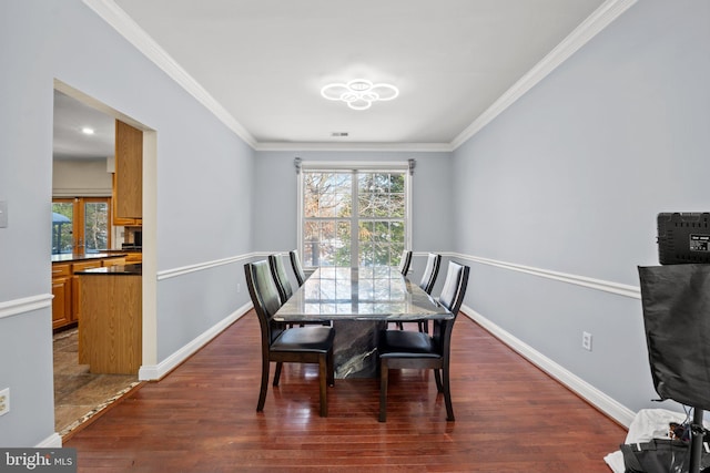 dining room with crown molding and dark wood-type flooring