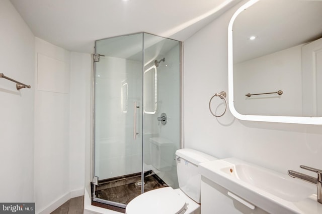 bathroom with sink, an enclosed shower, and toilet