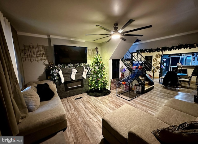 living room with crown molding, hardwood / wood-style floors, and ceiling fan