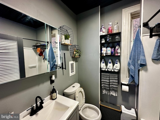 bathroom with vanity, toilet, and a shower