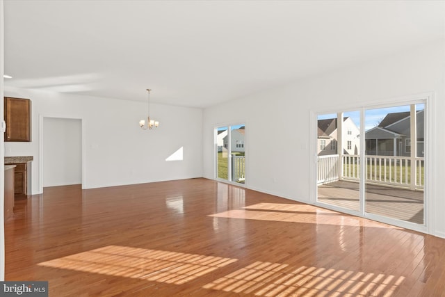 unfurnished living room featuring a chandelier and hardwood / wood-style floors