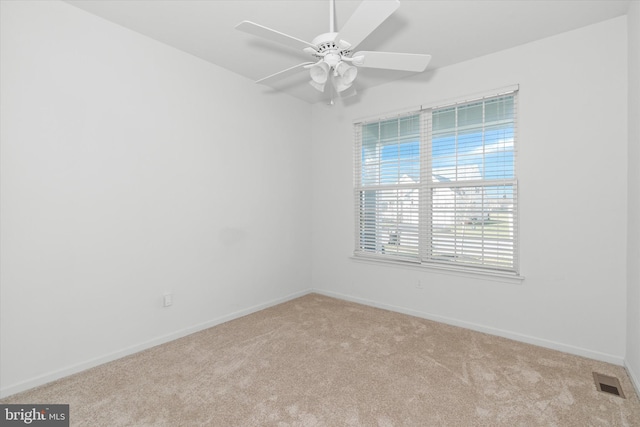 carpeted spare room featuring ceiling fan