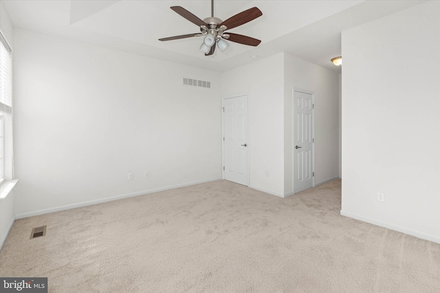 spare room with ceiling fan and light carpet