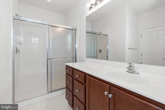 bathroom with tile patterned floors, vanity, and walk in shower