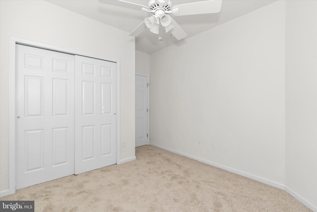 unfurnished bedroom with light carpet, a closet, and ceiling fan