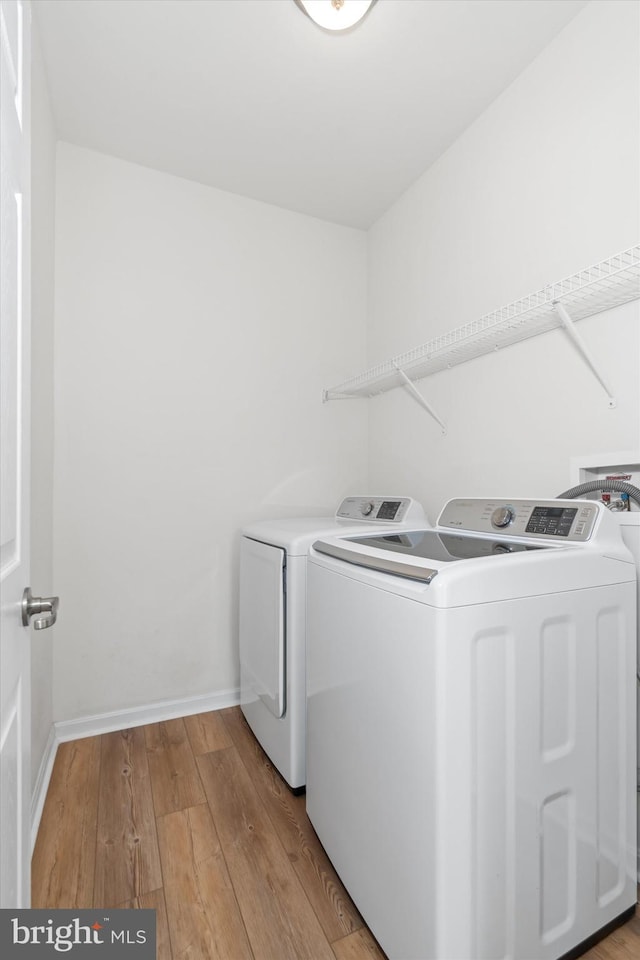 laundry area featuring light hardwood / wood-style floors and washing machine and dryer