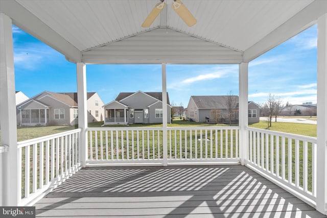 wooden deck featuring ceiling fan and a yard