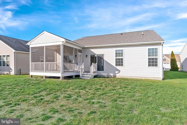 rear view of property featuring a sunroom and a lawn