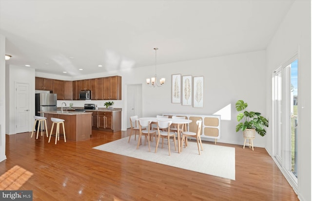 dining room with light hardwood / wood-style floors and an inviting chandelier