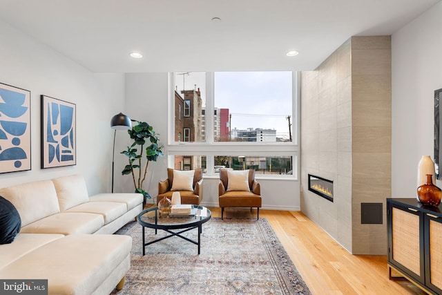 living room with light hardwood / wood-style flooring and a tiled fireplace