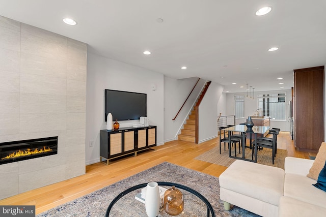 living room with light hardwood / wood-style floors and a tiled fireplace