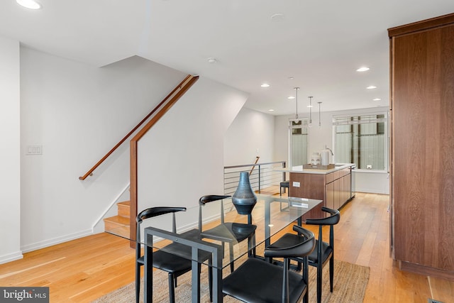 dining space featuring sink and light hardwood / wood-style flooring