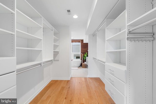 walk in closet with hardwood / wood-style flooring