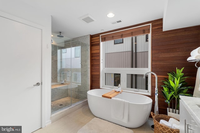 bathroom with tile patterned flooring, vanity, separate shower and tub, and wooden walls