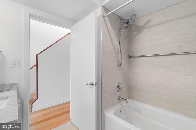 bathroom with vanity, tiled shower / bath combo, and hardwood / wood-style flooring