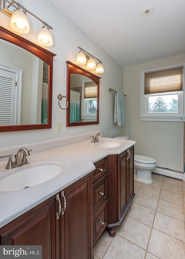 bathroom featuring tile patterned floors, vanity, toilet, and a baseboard radiator