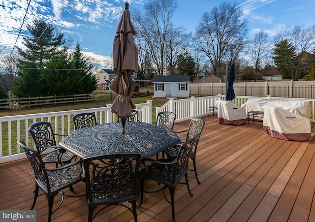 wooden deck with a storage shed and a yard