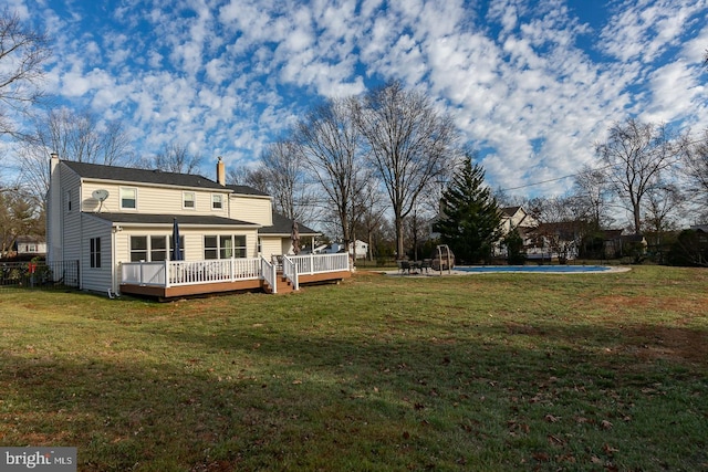 back of house featuring a swimming pool side deck and a yard