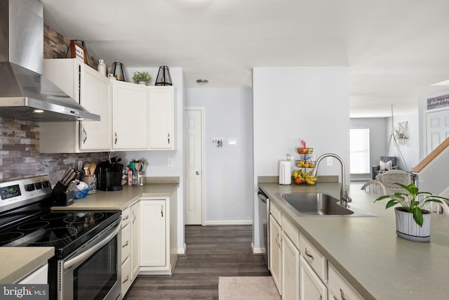 kitchen featuring white cabinetry, sink, stainless steel appliances, wall chimney range hood, and dark hardwood / wood-style floors