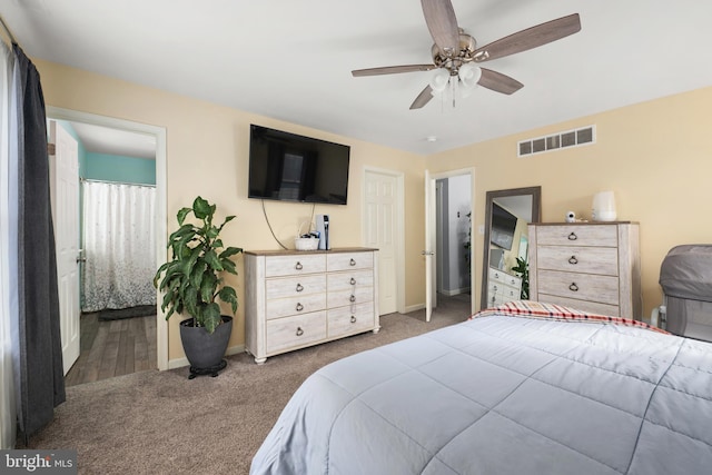 carpeted bedroom with ceiling fan and ensuite bathroom