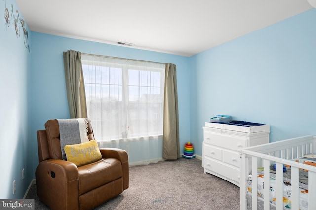 bedroom featuring light carpet and a nursery area