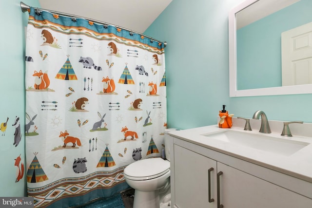 bathroom with vanity, curtained shower, and toilet