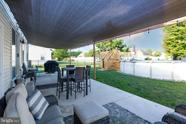 view of patio featuring a swimming pool side deck, an outdoor hangout area, and a grill