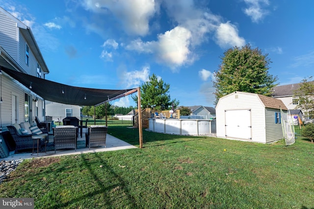 view of yard featuring an outdoor living space, a fenced in pool, a patio, and a storage shed