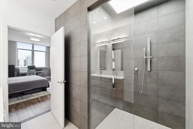 bathroom featuring tile patterned flooring, walk in shower, and tile walls