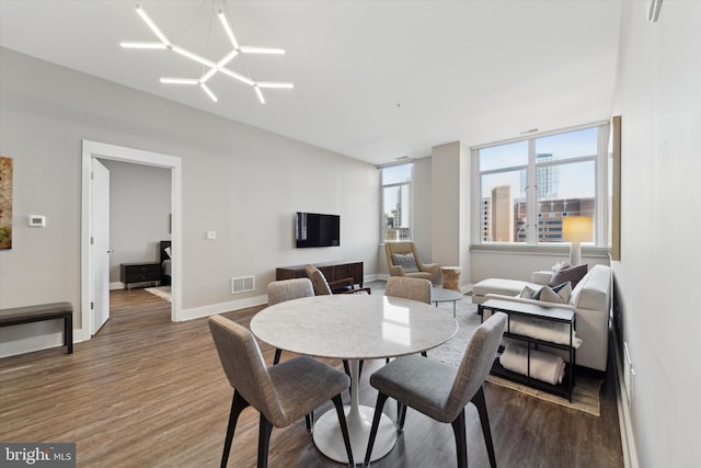 dining space featuring hardwood / wood-style floors and an inviting chandelier